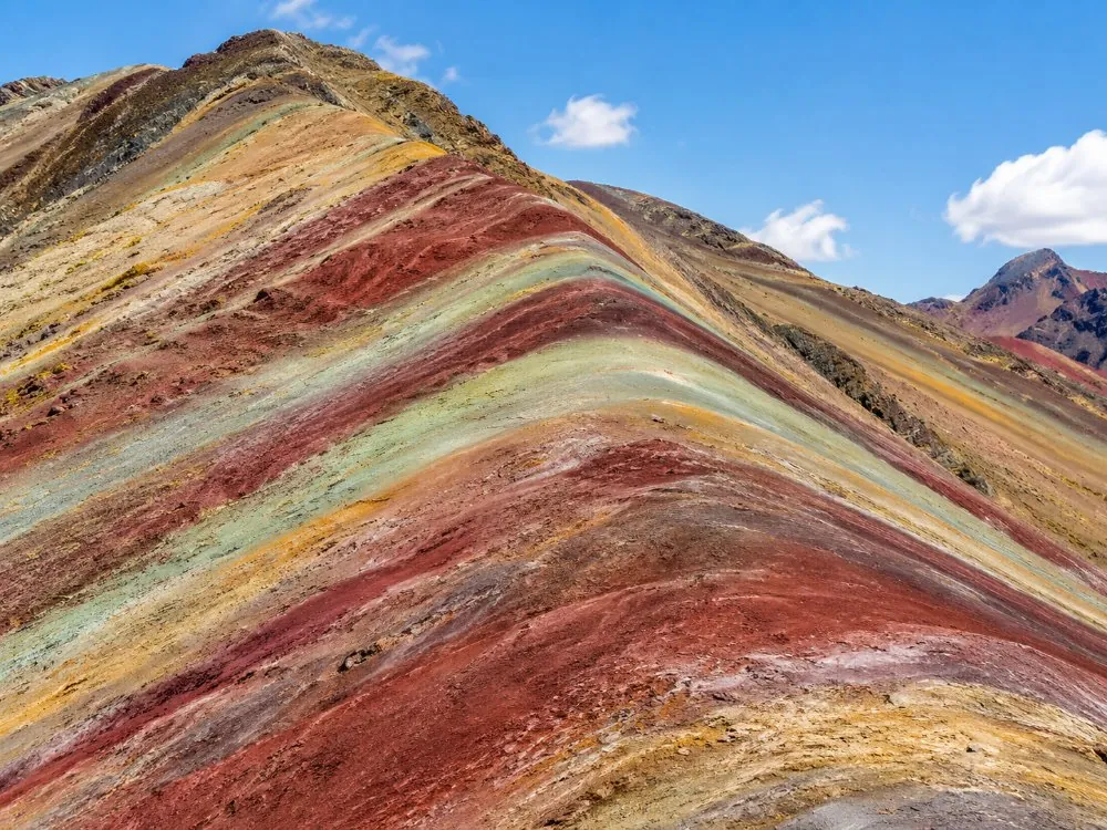Close view of red, mustard, green and lavender mineral bands on the mountainside